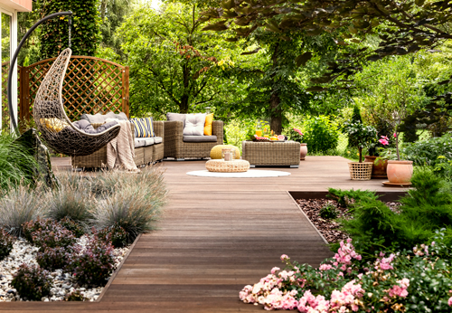 Wooden deck with walkway , surrounded by trees and flowers.