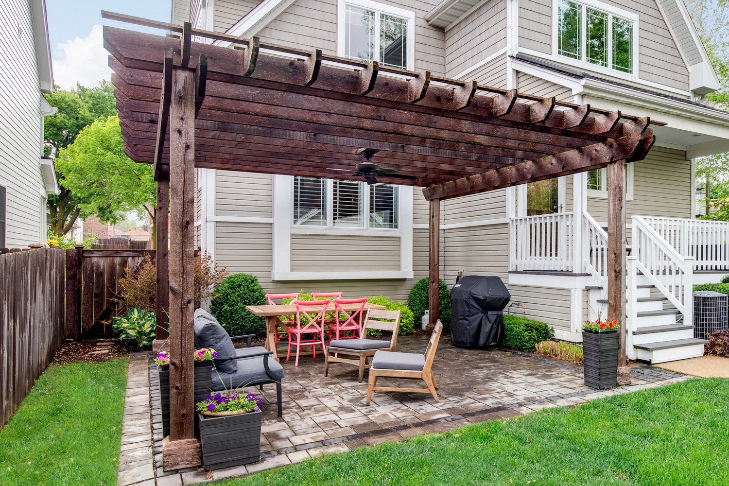Wooden pergola in front of residential house.